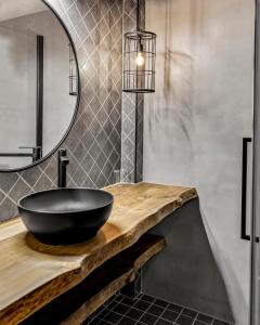 uma casa de banho com um lavatório preto e um espelho. em Canyon Hotell em Alta