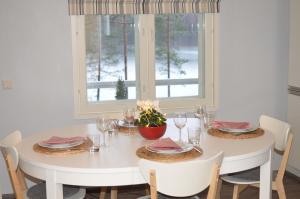 a white dining room table with chairs and a window at Kainiemen Huvilat in Nurmes