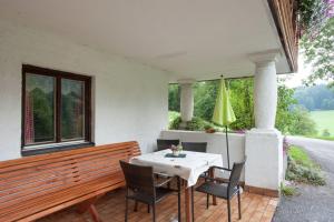 een tafel en stoelen op een patio met een raam bij Ferienwohnung im Haus Maria in Sankt Koloman