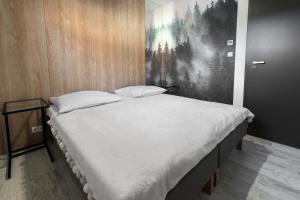 duże łóżko w pokoju z obrazem na ścianie w obiekcie Apartament Strumień w mieście Jaworki