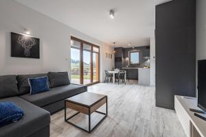 salon z kanapą i stołem w obiekcie Apartament Strumień w mieście Jaworki