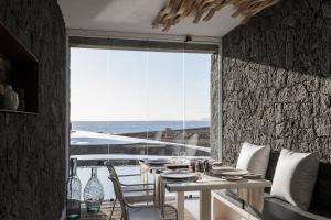 a dining room with a table and a large window at Kamezí Boutique Hotel Villas in Playa Blanca