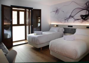 a hotel room with two beds and a couch at Hotel NERU con Encanto in León