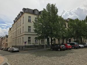 Un gran edificio con coches aparcados delante. en Zimmer im UG direkt in der Innenstadt, Centrum, en Schwerin