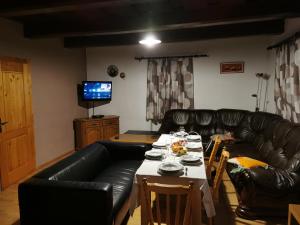 sala de estar con sofá de cuero negro y mesa en Chalupa U Potoka, en Staré Hory