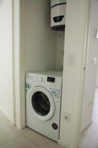 Una lavadora y secadora en una habitación blanca en Cala Blu Residence con piscina-Centralissimo Lido di Jesolo, en Lido di Jesolo