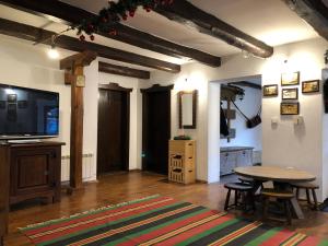 a living room with a table and a tv at Къща за гости Младата Баба in Apriltsi