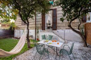 a patio with a hammock and a table and chairs at SECRET GARDEN - Amazing Loft in The Imperial Rome in Rome