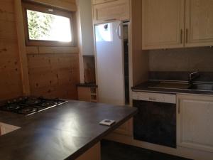 uma cozinha com um frigorífico branco e uma bancada em La Vardase em Le Grand-Bornand