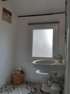 uma casa de banho com um lavatório e uma janela em Garden Annexe em Villeneuve-Loubet
