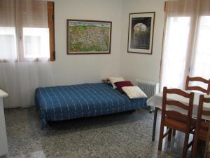 a small bedroom with a blue bed and a table at Apartamento Terranova Esquina Placeta in Alhama de Granada