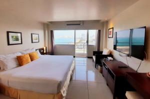 Pokój hotelowy z dużym łóżkiem i telewizorem w obiekcie Grand Hotel w Pattaya South