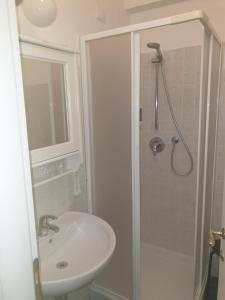 a white bathroom with a shower and a sink at Hotel Por Santa Maria in Florence