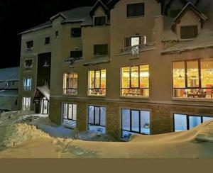 a large building in the snow at night at Studio Apartment Station Kopaonik,Milmari Resort in Kopaonik