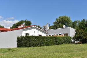 una casa blanca con un seto delante de ella en View Point Apart Pino en Villa Giardino