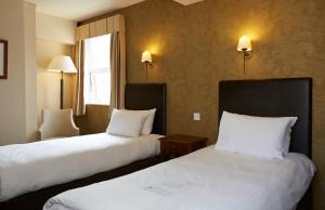 a hotel room with two beds and a window at Ye Olde Talbot Hotel by Greene King Inns in Worcester