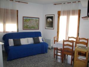 - un salon avec un canapé bleu et une table dans l'établissement Apartamento Terranova Esquina Placeta, à Alhama de Granada