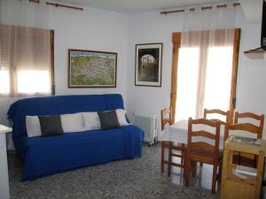 a living room with a blue couch and a table at Apartamento Terranova Esquina Placeta in Alhama de Granada