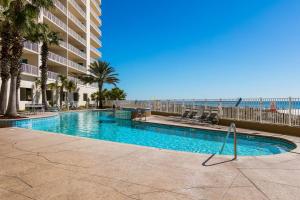 una piscina frente a un edificio con playa en Admirals Quarters, en Orange Beach