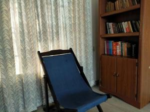 una silla azul en una habitación con estantería en Anashwara, en Kozhikode
