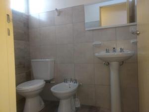 a bathroom with a toilet and a sink at View Point Apart Pino in Villa Giardino