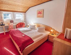 a bedroom with a large bed with a red blanket on it at Zeiserhof in Ramsau am Dachstein