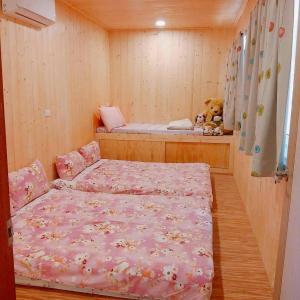 - une chambre avec un lit et un ours en peluche dans l'établissement Pu Shi Homestay, à Yuli