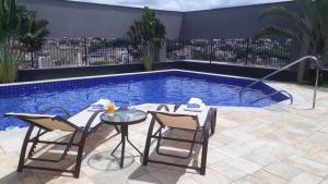 a patio with a table and chairs next to a swimming pool at Intercity São Paulo Anhembi in São Paulo