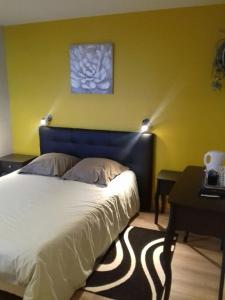 1 dormitorio con 1 cama con cabecero azul y mesa en Domaine Du Coteau Des Lys, en Fleurie