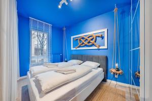 1 dormitorio con paredes azules y 1 cama grande en Apartamenty Sun & Snow Riverfront Gdańsk, en Gdansk
