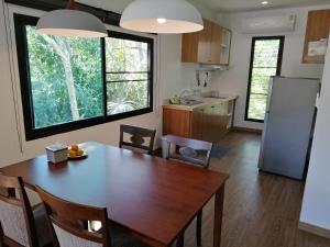 Ban Muang MaiにあるTwin Villaのテーブルと冷蔵庫のあるキッチンとダイニングルーム