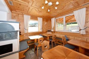 a log cabin dining room with wooden walls and windows at Al Piccolo Hotel in Vigo di Fassa
