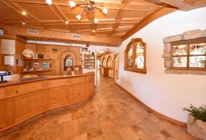 a large kitchen with a wooden ceiling and a counter at Al Piccolo Hotel in Vigo di Fassa