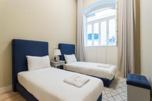 2 camas en una habitación con ventana en FLH Cais Sodré Trendy Duplex en Lisboa