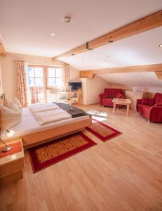 a bedroom with a large bed and a living room at Zeiserhof in Ramsau am Dachstein