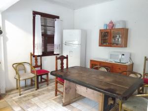 eine Küche mit einem Tisch und Stühlen sowie einem Kühlschrank in der Unterkunft Casa Siroba beira rio para 10 P in Morretes