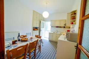 a kitchen with a table with chairs and a refrigerator at Leonidio Apartment Maria in Leonidio