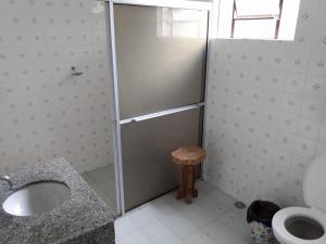 a bathroom with a shower and a sink and a toilet at Casa Siroba beira rio para 10 P in Morretes
