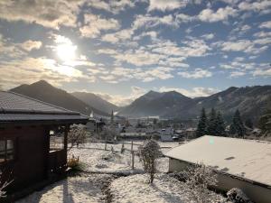 a view of a town in the snow with mountains at Ruhige Chalets mit Seeblick in zentraler Lage in Schliersee