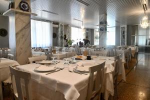 a dining room with white tables and white chairs at Hotel Villa Maria & Apartment in Varazze