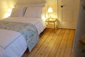 Un dormitorio con una cama y suelo de madera. en Falstaff House, listed building, a delightful late-Georgian holiday cottage in a great location in central Alnwick, en Alnwick