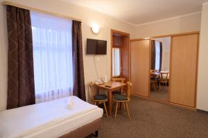 a hotel room with a bed and a table and a window at Zielone Wzgórze in Karpacz