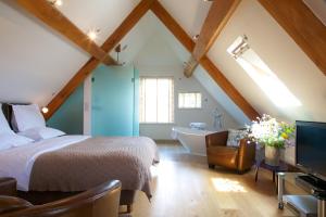 a bedroom with a bed and a bathroom with a tub at Eckington Manor in Pershore