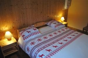 a bedroom with a bed with two lamps on both sides at Chalet Savoiage in Saint-Colomban-des-Villards