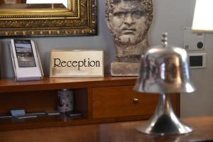einen Schreibtisch mit einer Statue des Kopfes und einer Schachtel in der Unterkunft Hotel Villa Maria & Apartment in Varraze