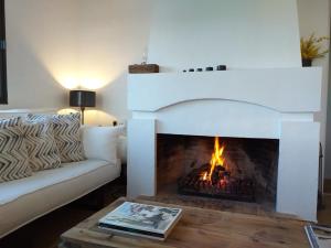 a living room with a fireplace and a couch at Casa Junto a la Playa in El Rompido +52 photos