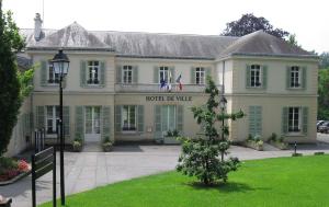 a building with a sign for the hotel de vile at Sweet New Apartment Close to Disneyland Paris in Thorigny-sur-Marne