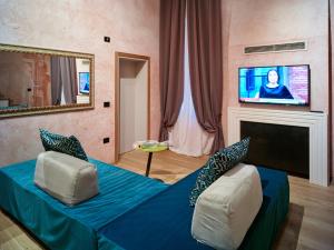 salon z łóżkiem i telewizorem z płaskim ekranem w obiekcie Ca' dei Proverbi Suites - WENICE Deep Culture w Wenecji