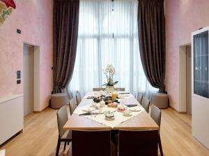 ein Esszimmer mit einem Tisch und Stühlen mit Essen drauf in der Unterkunft Ca' dei Proverbi Suites in Venedig