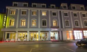 a large white building on a city street at night at Hotel Talija in Banja Luka